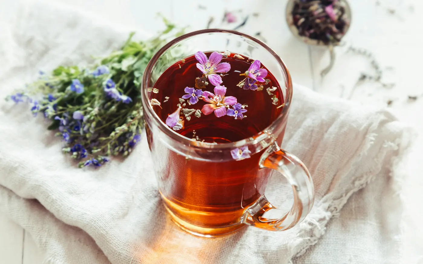 Herbal tea infusing with blossoms in a clear glass